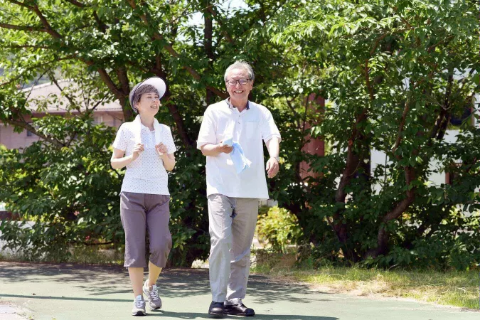 高齢者の夫婦が外で散歩をしている